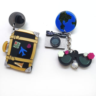 orecchini pendenti asimmetrici viaggio per veri viaggiatori con valigia nera, macchina fotografica argento, terra e occhiali da sole in plexiglass colorato tagliato al laser